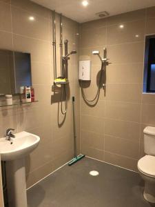 a bathroom with a shower and a toilet and a sink at The Oaks in Warminster