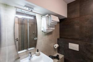 Un baño con lavabo, ducha y espejo. en Corso Apartments B&B, en Focşani 32 fotos más