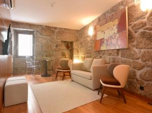 a living room with a stone wall at Casas Da Lapa, Nature & Spa Hotel in Seia