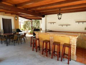 un patio con bar, mesa y sillas en Villa María - Pista de Padel y Piscina, en Baena