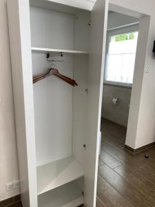 a walk in closet with white shelves and a window at Domi's Gästehaus in Bergheim