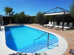 una piscina con sillas y un cenador en Villa María - Pista de Padel y Piscina, en Baena
