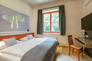 Łóżko lub łóżka w pokoju w obiekcie JUFA Hotel Mariazell