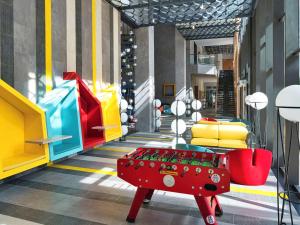 头顿ibis Styles Vung Tau的大厅,房间中间有一个红色的搁脚凳