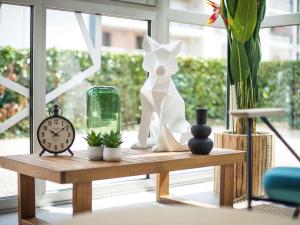 une table avec une horloge et des vases sur une fenêtre dans l'établissement Ibis Tours Centre Giraudeau, à Tours