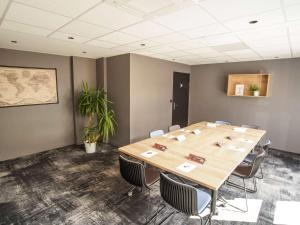 uma sala de conferências com uma grande mesa de madeira e cadeiras em Ibis Tours Centre Giraudeau em Tours