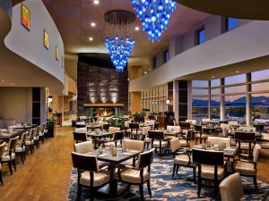 a dining room with tables and chairs and windows at Fairmont Vancouver Airport In-Terminal Hotel in Richmond