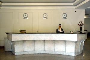 a woman sitting at a reception desk in a lobby at Armenian Village Park Hotel & Water Park in Yerevan