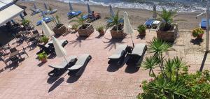 a group of chairs and umbrellas on a beach at Artemis Hotel in Amarinthos