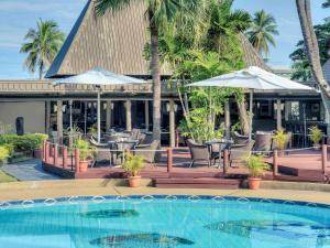 a resort with a pool and chairs and umbrellas at Mercure Nadi in Nadi