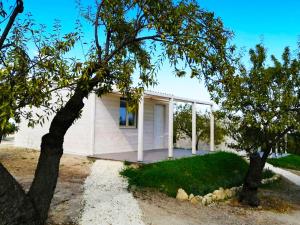 una casa blanca con árboles delante de ella en Mennuli&Alivi - Organic Farm en Noto