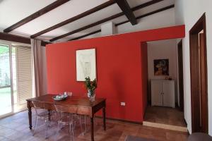 a room with a table and a red wall at Casa Castagna in Caserta