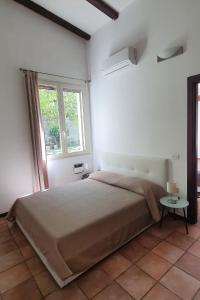 una camera con un grande letto e una finestra di Casa Castagna a Caserta