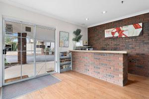 a room with a brick wall and a counter at Econo Lodge Border Gateway Wodonga in Wodonga