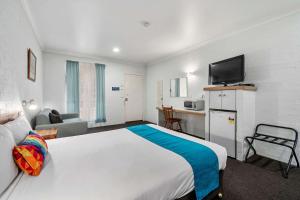 ein Hotelzimmer mit einem großen Bett und einem TV in der Unterkunft Econo Lodge Border Gateway Wodonga in Wodonga