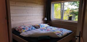uma pequena cama num quarto com uma janela em Apartmán Nežichov em Toužim