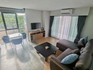 ein Wohnzimmer mit einem Sofa und einem Tisch in der Unterkunft RICO Hotel Ratchadapisek 32 in Bangkok