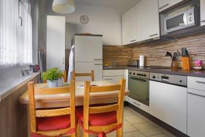 La cuisine est équipée d'une table, de chaises et d'un réfrigérateur. dans l'établissement H&H Apartment im Herzen der Stadt Nr 29-Henning mit Balkon, à Greifswald