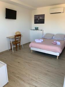 a bedroom with a bed and a desk and a table at Casa Julie in Patrimonio