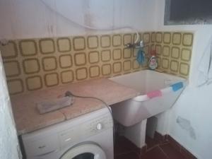 a small bathroom with a washing machine in it at Aspra Beach in Ficarazzi