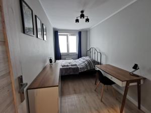 een slaapkamer met een bed, een bureau en een tafel bij Stare Miasto in Głogów