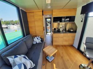 salon z kanapą i kuchnią w obiekcie Domki pływające Houseboat4U, Mazury w mieście Ruciane-Nida