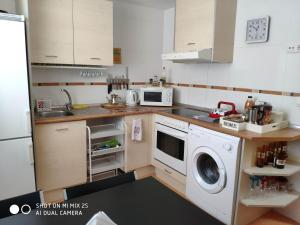 a small kitchen with a washer and dryer in it at Casa el Sol in Lumpiaque