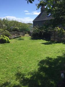 a yard with a house and a grass field at George's House - 1 Leacklee in Manish