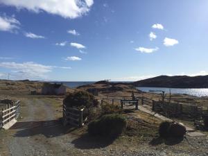 a fence on a dirt road next to a body of water at George's House - 1 Leacklee in Manish