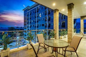 a balcony with a table and chairs and a building at Lux Boutique Hotel in Nonthaburi