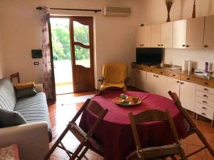 a living room with a table and a kitchen at Casa Terme Romane in Castelsardo