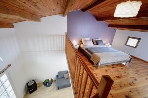 1 dormitorio con 1 cama y escalera de madera en Domaine du Conte Bleu en Sainte-Gemme
