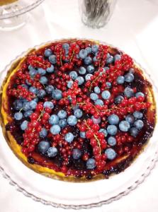a cake with berries on top of it on a table at Hotel Leon D'Oro in Castelfrentano
