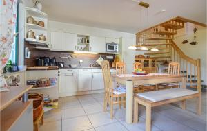 eine Küche mit einem Tisch und Stühlen sowie eine Treppe in der Unterkunft Ferienhaus Wendisch-Rietz Rohrweihe, Luisenaue III in Wendisch Rietz
