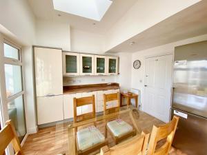 a kitchen with a table and chairs and a refrigerator at Basingstoke Townhouse Near Hospital in Basingstoke