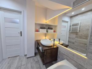 a bathroom with a white sink and a shower at Lux Apartment Modern in Polanica-Zdrój