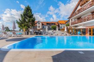 a swimming pool in a resort with chairs and umbrellas at Hotel Kahlberg in Krynica Morska