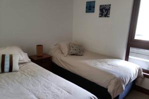 a bedroom with two beds and a window at Pucon Parque Pinares (playa privada) in Pucón +19 photos