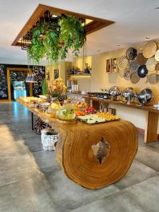 Natal Dunnas Hotel في ناتال: مطبخ مع طاولة خشبية كبيرة مليئة بالطعام