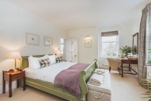 sypialnia z zielonym łóżkiem, biurkiem i stołem w obiekcie Craigellachie Hotel of Speyside w mieście Craigellachie