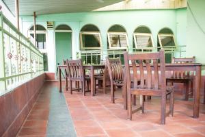 a restaurant with wooden chairs and a table at Suus Rahma Guest House & Apartments in Accra