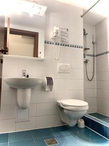 La salle de bains est pourvue de toilettes et d'un lavabo. dans l'établissement Hotel Roberts, à Sibiu