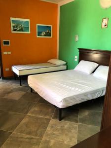 Duas camas num quarto com paredes verdes e laranja em Bed & Breakfast 101 em Galatina