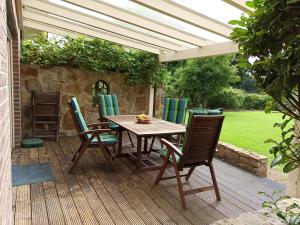 a wooden table and chairs on a wooden deck at Ferienwohnung Wittrock in Bad Bentheim