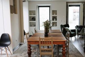 a dining room with a wooden table and chairs at Madrinha Country House in Antas