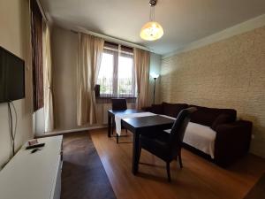 ein Wohnzimmer mit einem Tisch und einem Sofa in der Unterkunft Lux Apartment Art in Polanica-Zdrój