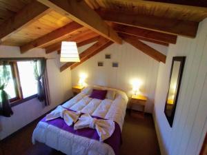 um quarto no sótão com uma cama e 2 janelas em Altos del Pucará Piscina Climatizada Juegos infantiles Huerta Orgánica em Huerta Grande