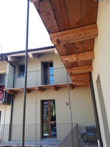 einen Balkon eines Hauses mit Holzdach in der Unterkunft Appartamenti il borgo papavero in Busca