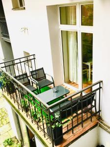 een balkon met een glazen tafel en stoelen bij Old Time Apartments in Krakau