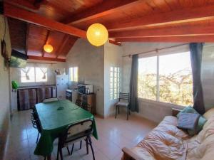 a living room with a table and a couch at Altos del Pucara Piscina Climatizada vista a las sierras juegos Huerta Orgánica in Huerta Grande